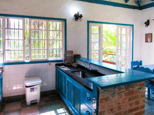 a kitchen with a blue counter and a sink at Casa com saida privativa para a Praia do Felix SP in Ubatuba