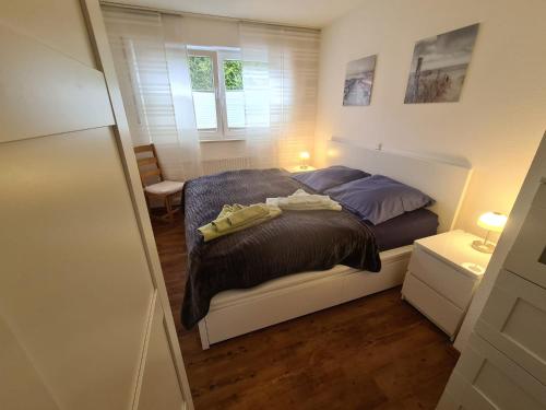 een kleine slaapkamer met een bed en een raam bij Pier 605 - 4 Sterne inklusive POWER WLAN - 2 Parkplätze - Wäschepaket #Bestpreisgarantie# in Zingst
