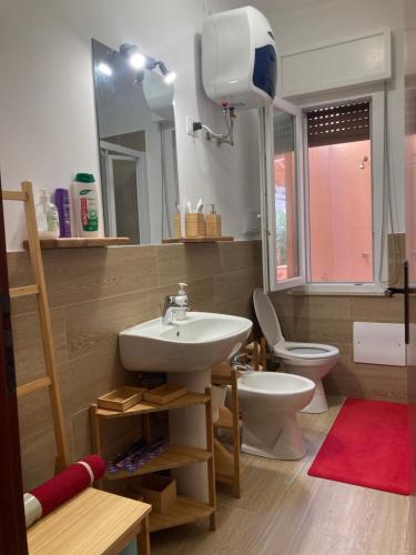 ein Badezimmer mit Waschbecken, Toilette und Spiegel in der Unterkunft Like Home Calamazzo di Sciacca in Scopello