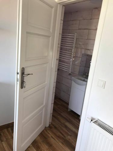 a bathroom with a white door and a sink at Noclegi U Bram Klasztoru in Stary Sącz