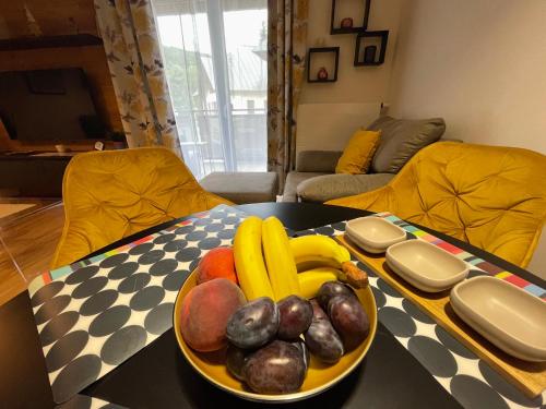 a bowl of fruit on a table in a living room at Luxusní apartmán GRAND v centru Harrachova se saunou, wallboxem EV, parkováním zdarma, Netflix a HBO, velkým balkonem a výhledem na Čertovu horu ,sjezdovku a skokanské můstky in Harrachov