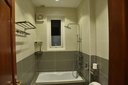 a bathroom with a shower and a bath tub at Đà Lạt Villa 84 Hồ Xuân Hương in Da Lat