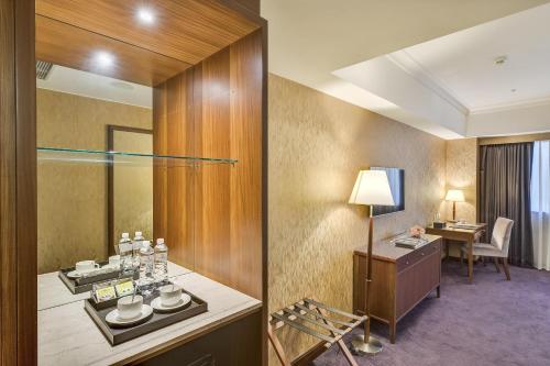 a hotel room with a vanity and a table and a desk at Fuji Grand Hotel in Xizhi