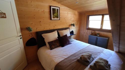1 dormitorio con 1 cama en una cabaña de madera en Valley Lodge, en La Bresse