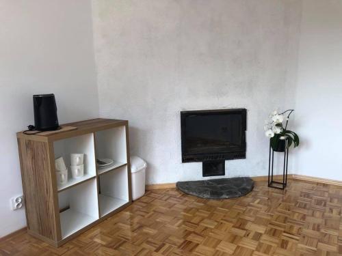 a living room with a fireplace and a television at Noclegi U Bram Klasztoru in Stary Sącz