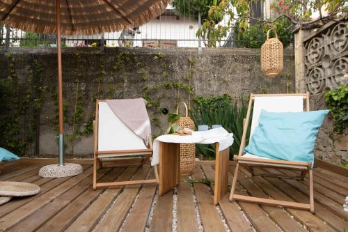 dwa krzesła i stół na patio w obiekcie VITEDIMARE APARTMENT SOLE - SUN w mieście Muggia