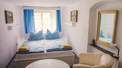 ein kleines Schlafzimmer mit einem Bett und einem Spiegel in der Unterkunft Penzion 1670 in Nové Hrady