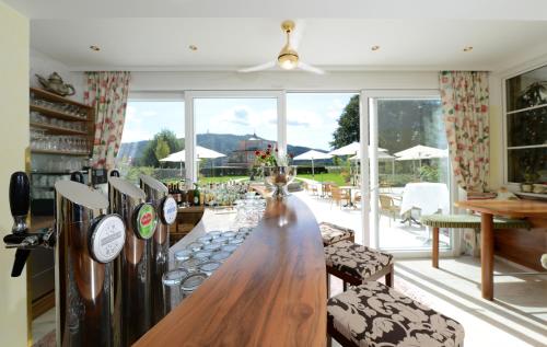 a living room with a long table and a large window at Seehotel Astoria in Pörtschach am Wörthersee