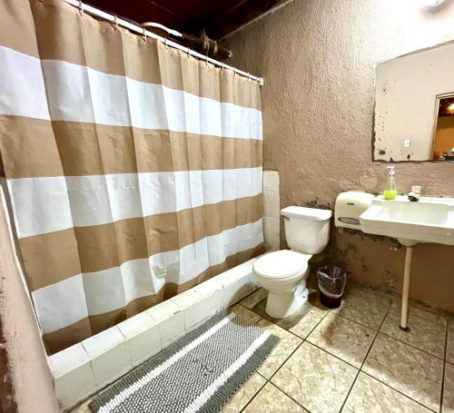 a bathroom with a toilet and a sink at Johnnys Place Hotel in Monterrico