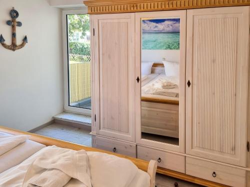 ein Schlafzimmer mit einem großen weißen Schrank mit einem Fenster in der Unterkunft Ferienwohnung Sonnenblick in Sassnitz