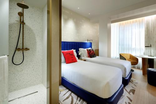 Cette chambre comprend deux lits et une salle de bains. dans l'établissement Hard Rock Hotel Madrid, à Madrid