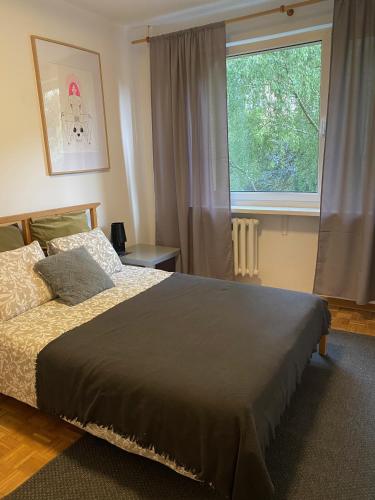 a bedroom with a bed and a large window at Burgaska 5 XL Size in Warsaw