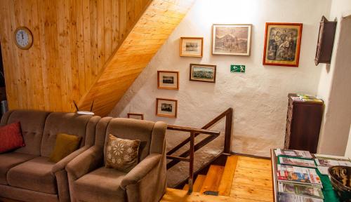 a living room with a couch and a staircase at Penzion 1670 in Nové Hrady