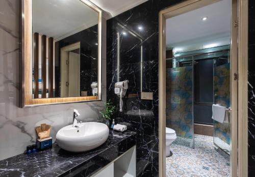 a bathroom with a sink and a toilet and a mirror at Bendecir Hotel & Spa in Hanoi