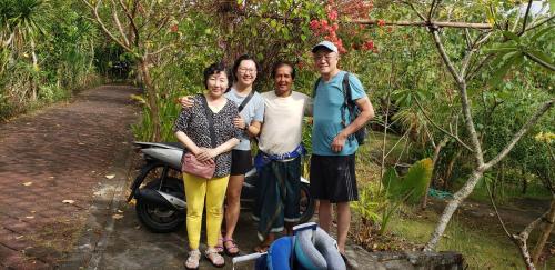a group of people standing next to a scooter at Pier26 Bali Homestay in Nusa Dua