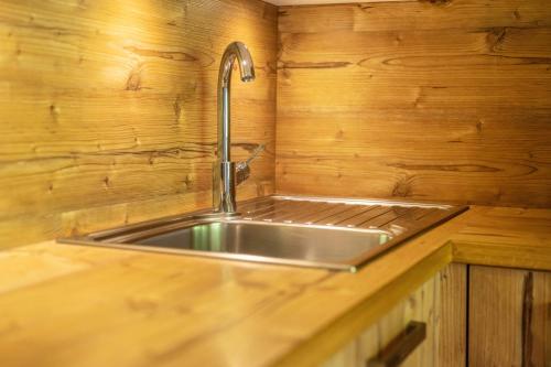 a stainless steel sink in a wooden kitchen at Zimmerhofer A3 Panorma in Cadipietra