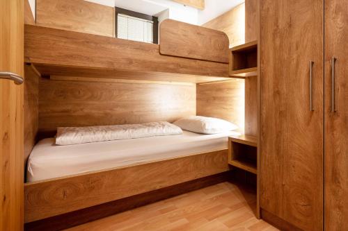 a bedroom with wooden cabinets and a bed in it at Zimmerhofer C Dolomiti in Cadipietra