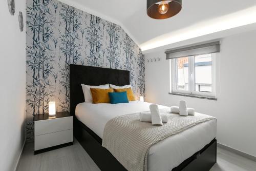 Un dormitorio con una cama grande y una ventana en Beach Alley Apartment, en Nazaré