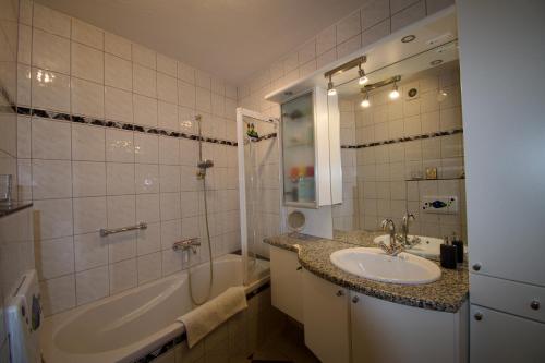 a bathroom with a sink and a tub and a shower at Ferienwohnung EifelMittendrin in Waxweiler
