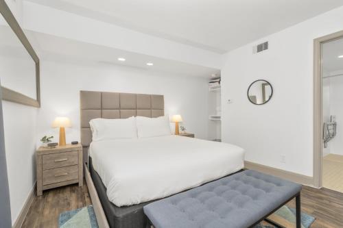 a bedroom with a large white bed and a bench at Studio w Handicap access - Walk to Texas Medical Center, NRG, Rice University, Parks, Zoo in Houston