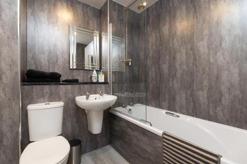 a bathroom with a toilet and a sink and a tub at Lovely City Centre 1 bedroom flat. in Perth