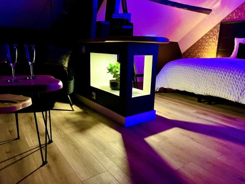 a room with a night stand with a plant in it at L'Intemporel Suite Spa in Champagne-sur-Oise