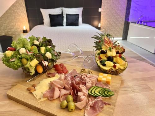 una mesa con comida en una habitación de hotel en L'Intemporel Suite Spa, en Champagne-sur-Oise