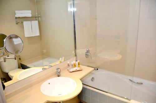 a bathroom with a sink and a toilet and a tub at Hotel Terranova in Pas de la Casa