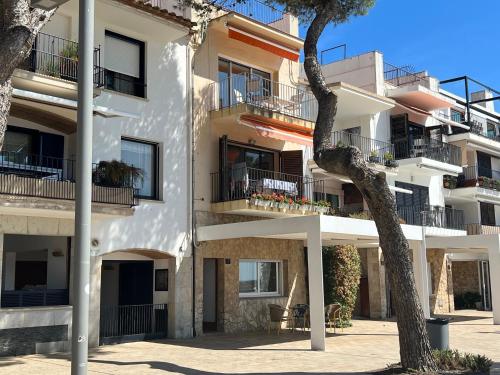 an apartment building with balconies and a tree at Apto. Plana - 374 in Llafranc