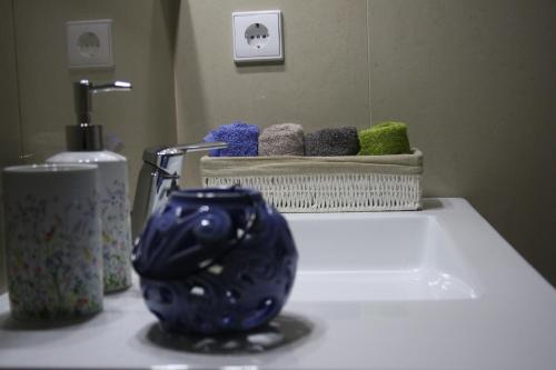 ポルトにあるChillHouse_Portoの洗面台の横に青い花瓶が置かれたバスルームカウンター