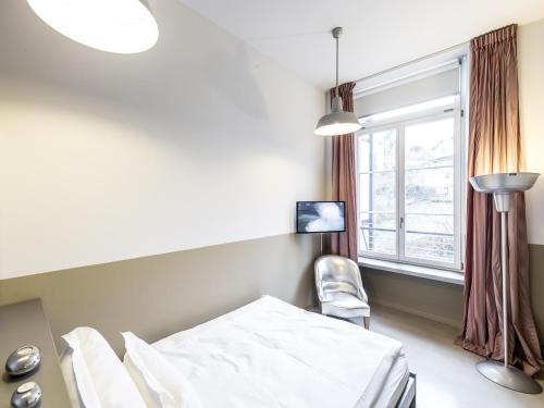 ein Krankenzimmer mit einem Bett und einem Fenster in der Unterkunft lofthotel Walensee in Murg