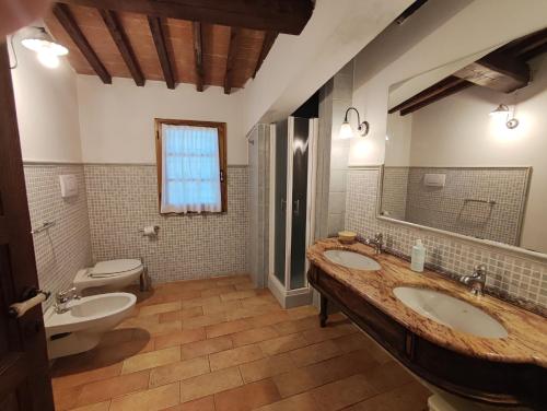 a bathroom with two sinks and a toilet at Agriturismo Santa Cristina in Gambassi Terme