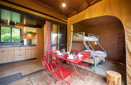 a room with a red table and a bunk bed at CAMPING ONLYCAMP CHAMARGES in Die