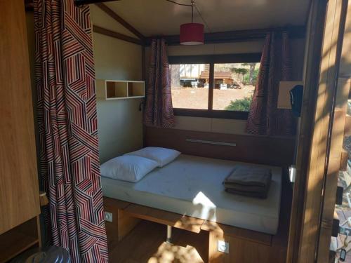 a small bed in a room with a window at CAMPING ONLYCAMP CHAMARGES in Die