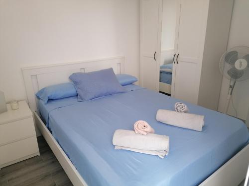 a bedroom with a bed with towels and a fan at BRISAMAR Apartamento con aire acondicionado in Torremolinos