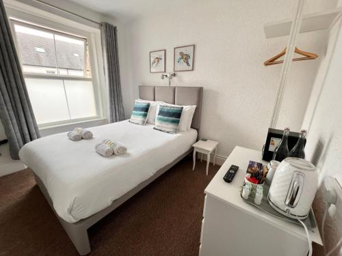 a bedroom with a bed with towels on it at Gumfreston Guest House in Tenby