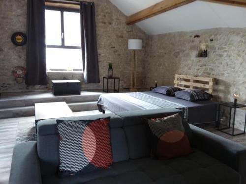 une chambre avec un lit et un canapé dans l'établissement Gîte - à l'Ombre du Teil, à Bouville