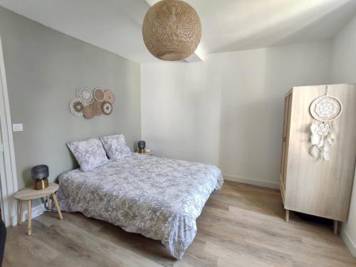 1 dormitorio con 1 cama y suelo de madera en La Nacre de Saint Aubin sur Mer, en Saint-Aubin-sur-Mer