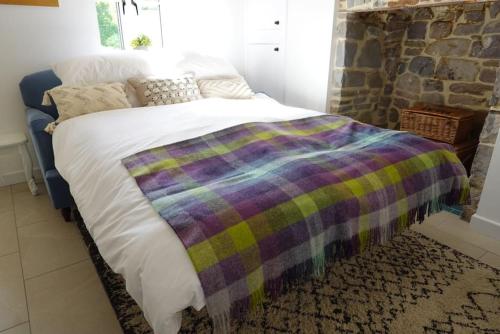 ein Schlafzimmer mit einem Bett mit einer Decke darauf in der Unterkunft River Cottage in Abercraf