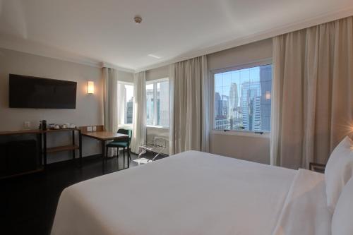 um quarto de hotel com uma cama grande e uma janela grande em Park Inn by Radisson Berrini em São Paulo