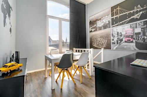 a dining room with a table and chairs and a yellow car at Appartement 20 min du Circuit Spa-Francorchamps, in Verviers