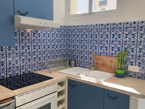 een keuken met blauwe en witte tegels op de muur bij La terrasse Apartment Five stars holiday house in Nice