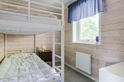 Rural apartment in Sjoared في ماركاريد: غرفة نوم بسريرين بطابقين ونافذة