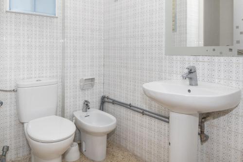 a white bathroom with a toilet and a sink at Lider, 12-G in Cullera