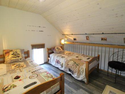 a bedroom with two beds and a table in it at Au tour des sens in La Jumellière
