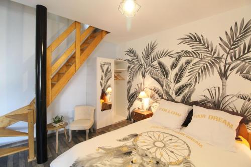 una camera da letto con un letto con un murale di palme sul muro di Au tour des sens a La Jumellière