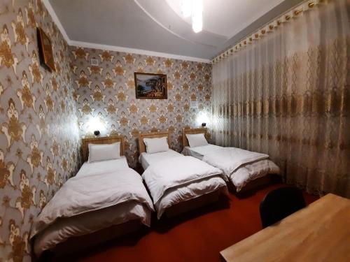 three beds in a room with wallpaper at Зона отдых APACHI в горах ЧИМГАН in Chimgan