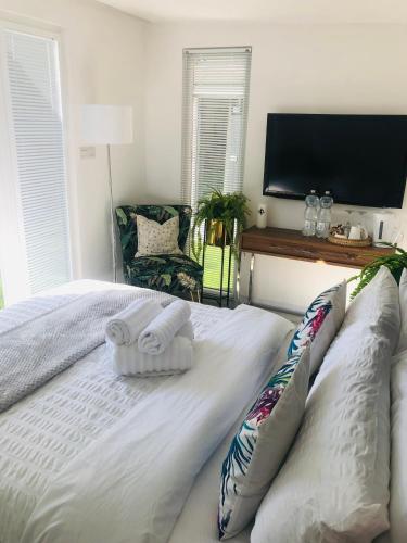 a white bed with two pillows and a flat screen tv at MeeZee Pearl Double Bed Lodge With Free Parking in Manchester