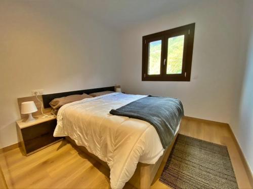 - une chambre avec un grand lit et une fenêtre dans l'établissement Apartamento en Encamp, Anyó 2. Hasta 6 personas, à Encamp