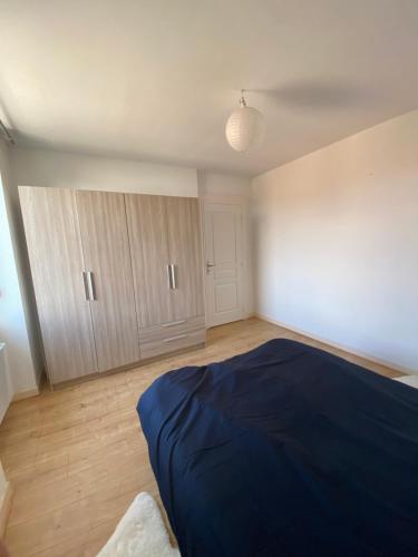 - une chambre avec un lit bleu et du parquet dans l'établissement le repos vésulien, à Navenne